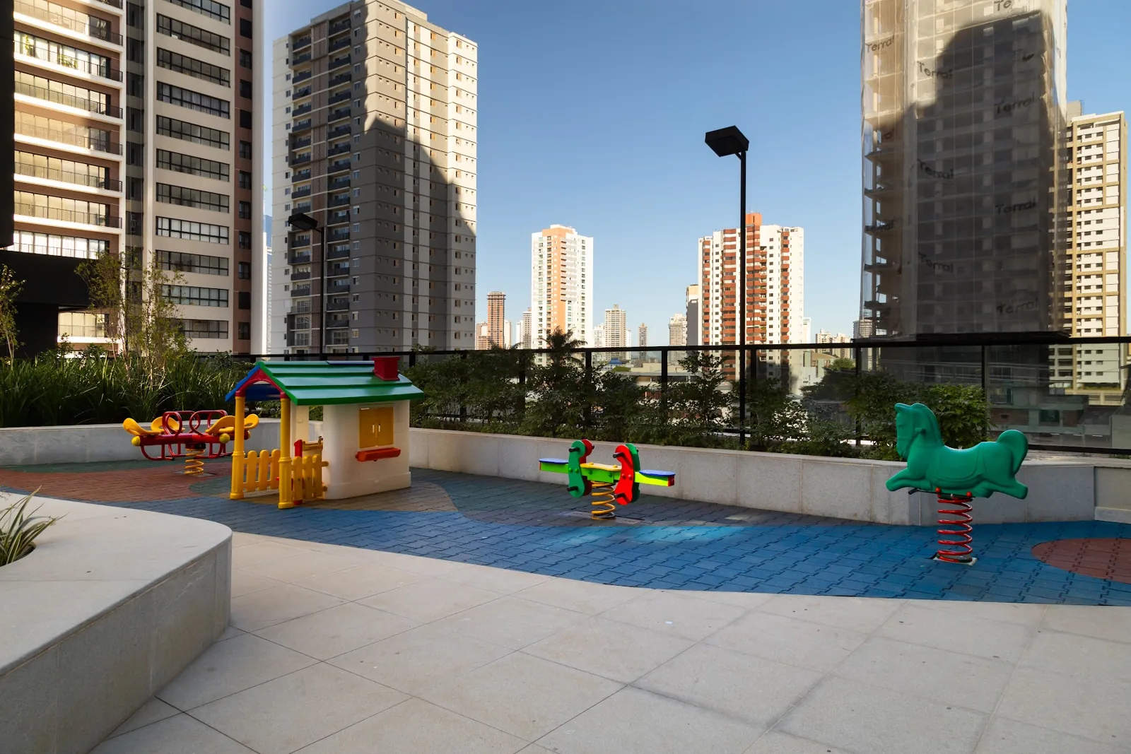 Área externa de lazer com playground e skyline de Goiânia